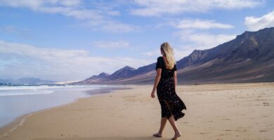 Dónde se rodó Han Solo en Fuerteventura: localizaciones y cómo visitarlas 1 Mujer caminando por la playa de Cofete con las montañas de Jandía al fondo, en Fuerteventura