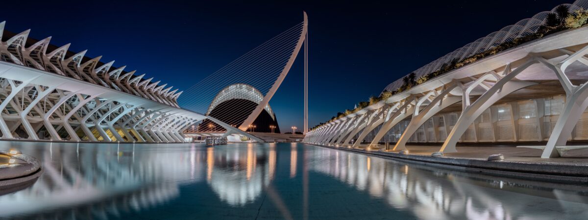Ciudad de las Artes y las Ciencias de Valencia iluminada de noche y reflejada en el agua