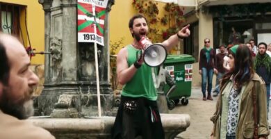 Ruta por los escenarios de Ocho apellidos vascos 1 Escena de Ocho apellidos vascos en una plaza de Zumaia con una persona hablando por megáfono