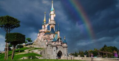 El Castillo de la Bella Durmiente de Disneyland París con un arcoíris en el cielo