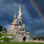 El Castillo de la Bella Durmiente de Disneyland París con un arcoíris en el cielo