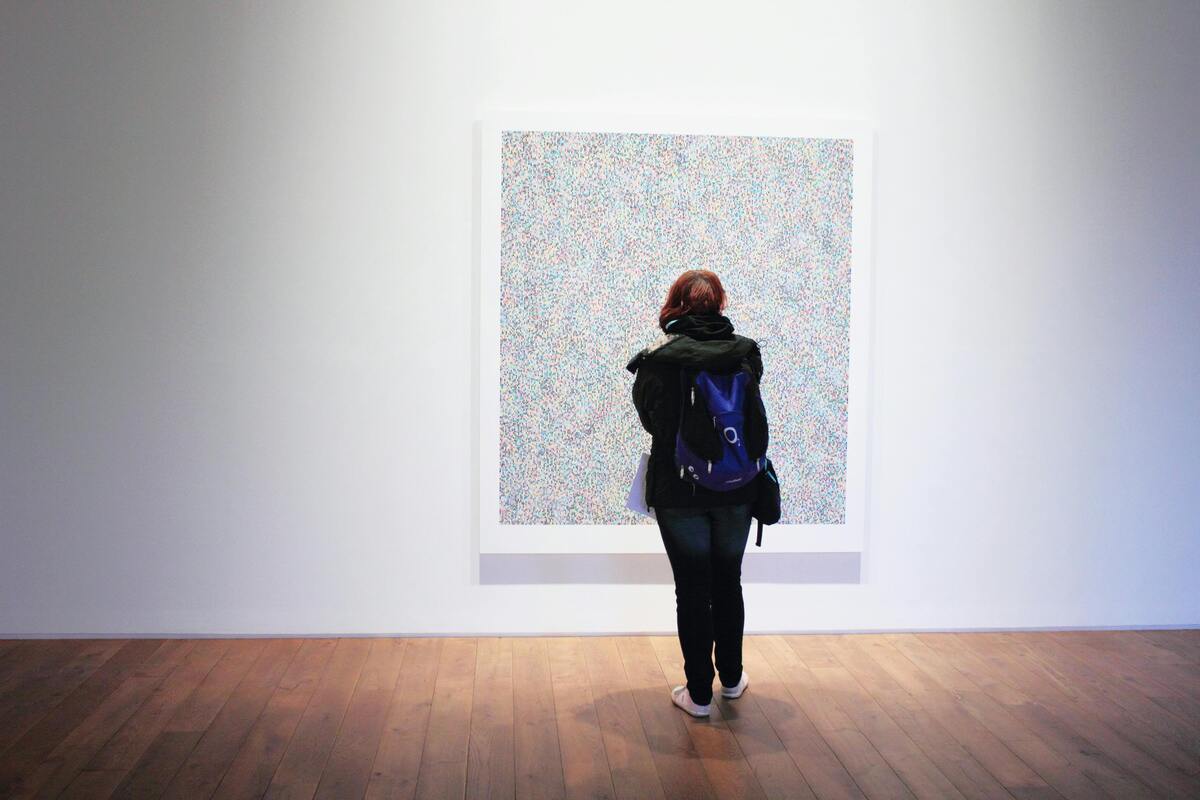 Una mujer observa un cuadro en un museo