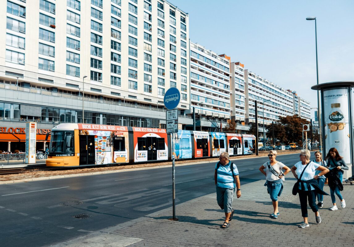 Tranvía circulando por una avenida de Berlín junto a edificios y peatones