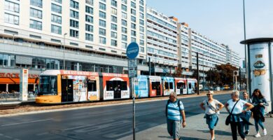 Dónde alojarse en Berlín: mejores zonas según tu viaje y presupuesto 2 Tranvía circulando por una avenida de Berlín junto a edificios y peatones