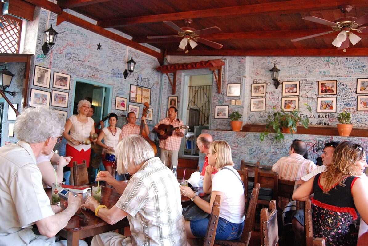 Interior de La Bodeguita del Medio en La Habana con clientes y músicos cubanos