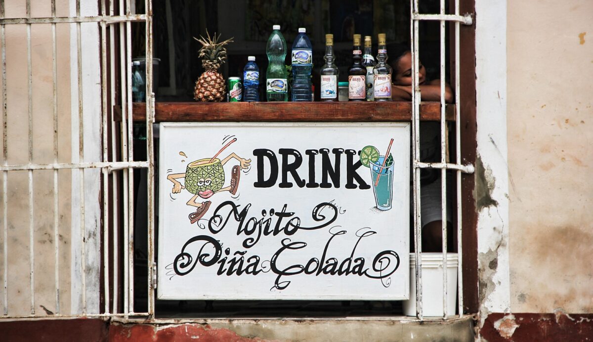 Cartel anunciando mojitos y piñas coladas en un pequeño bar de Cuba