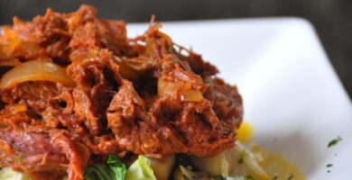 Plato de ropa vieja cubana con carne deshilachada, verduras y salsa