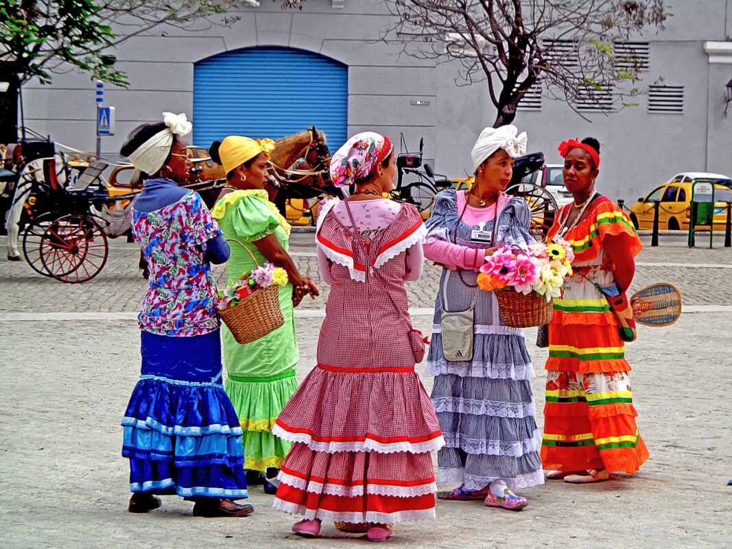Mujeres con vestidos tradicionales conversando en una plaza de La Habana, Cuba