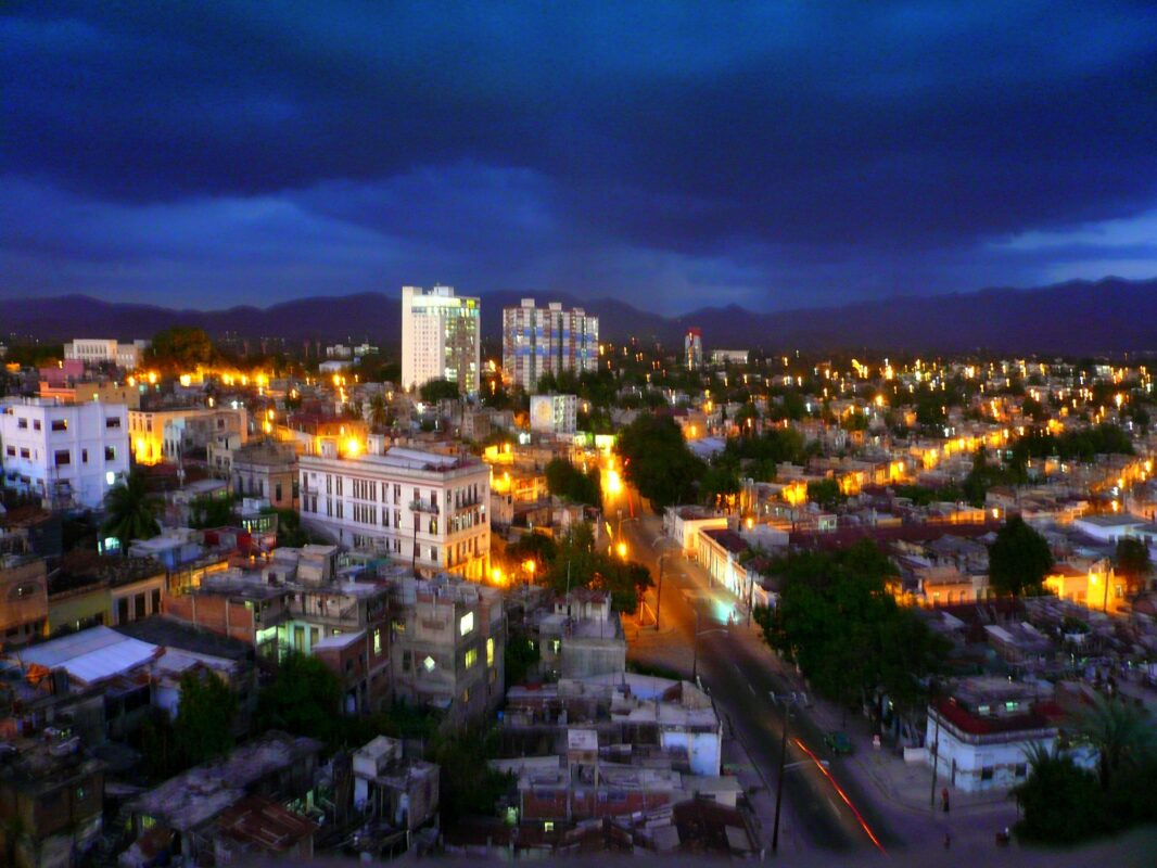 Vista panorámica de Santiago de Cuba iluminada al anochecer