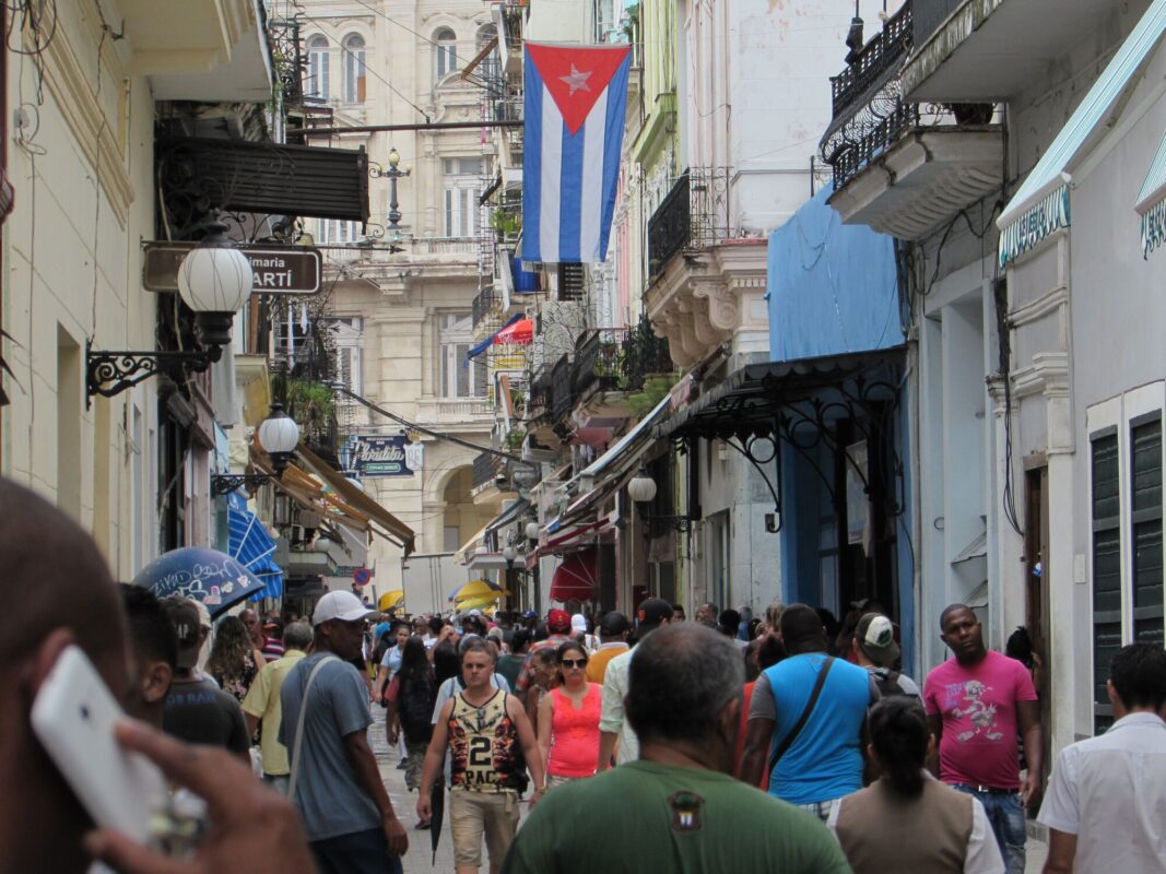 Calle Obispo llena de gente bajo una bandera cubana en La Habana Vieja