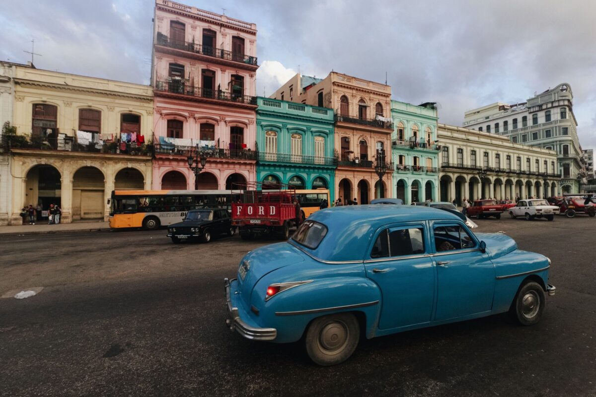 Coche clásico azul circulando frente a edificios coloniales de La Habana