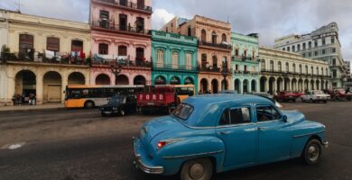 Coche clásico azul circulando frente a edificios coloniales de La Habana